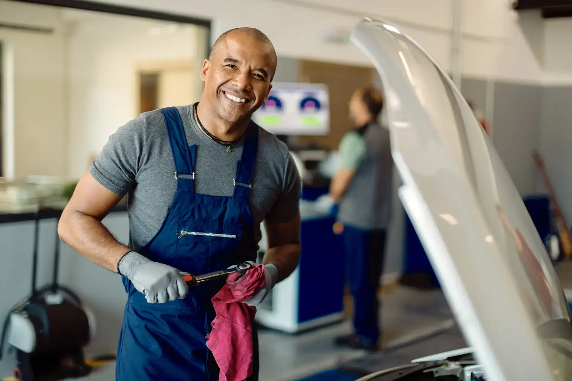 happy-black-auto-mechanic-working-at-car-workshop-2023-11-27-04-49-41-utc-scaled