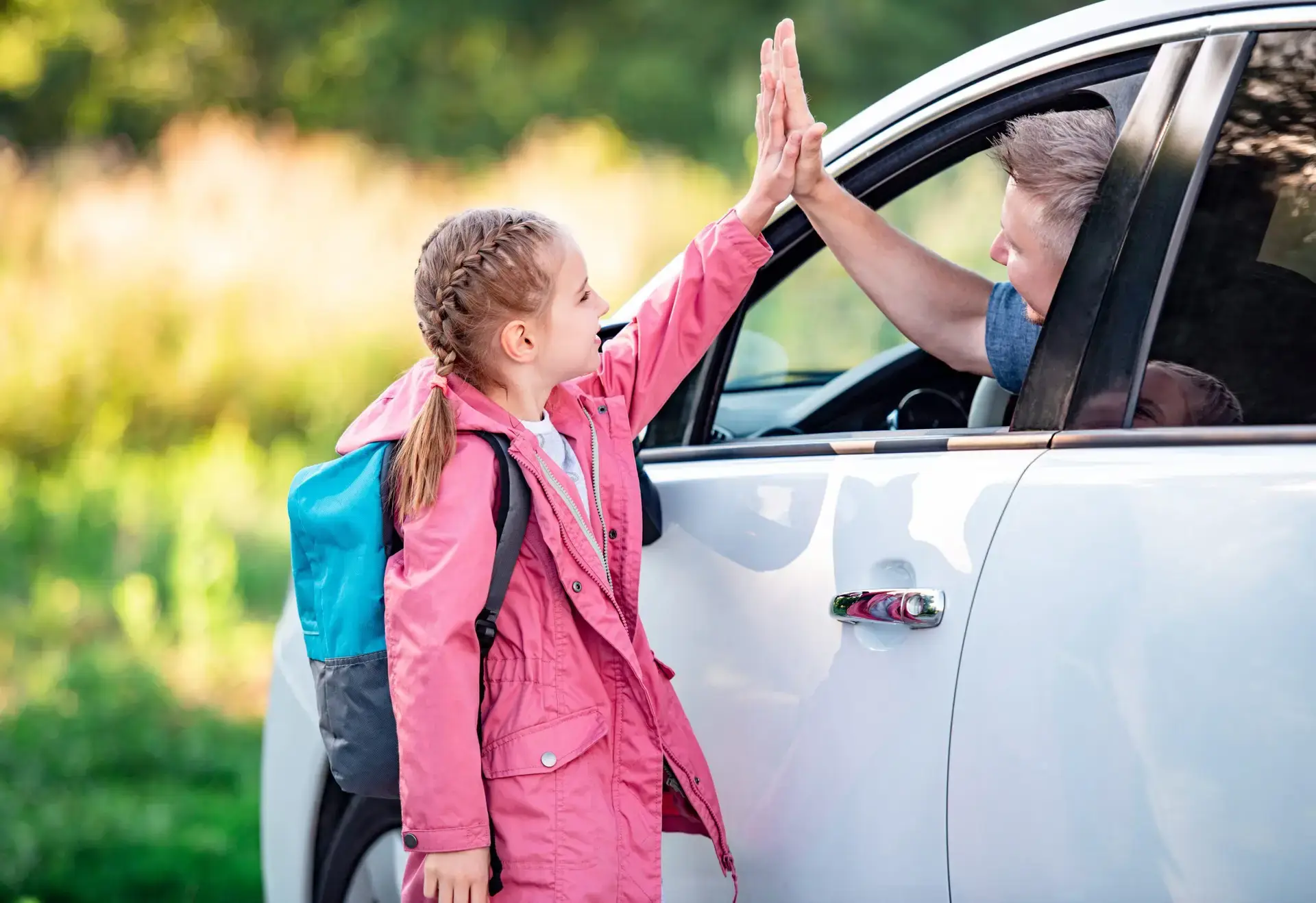 schooler-giving-five-to-father-in-car-2023-11-27-05-25-33-utc-scaled